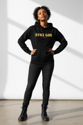Brown-skinned woman wearing DYKE GOD hoodie in bold gold lettering